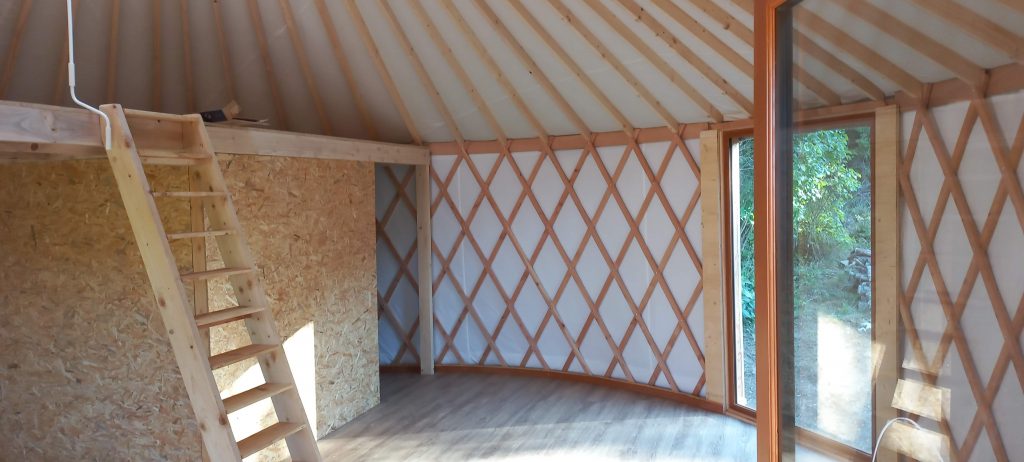 Intérieur d'une yourte contemporaine avec mezzanine et salle de bains