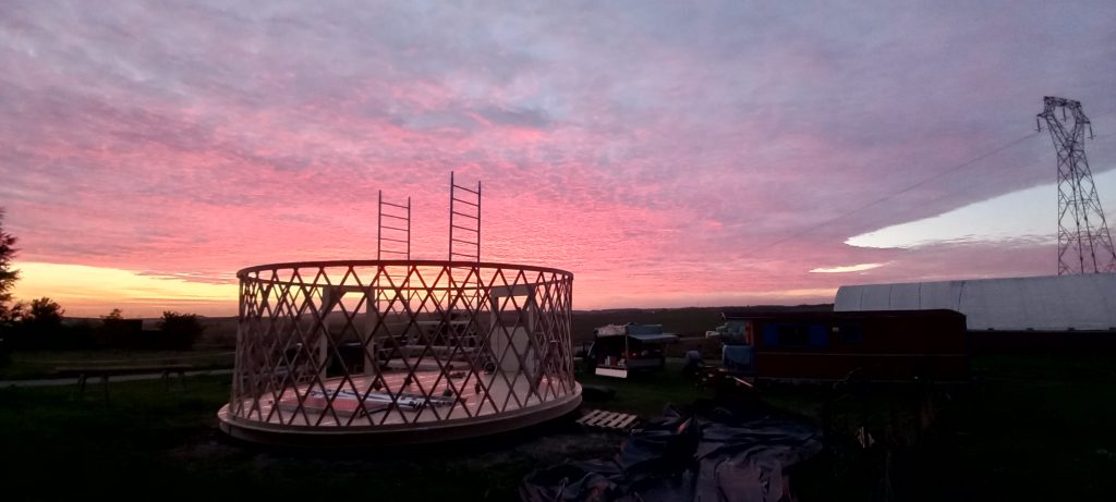 ossatures en bois sans charpente d'une yourte lors d'un coucher de soleil