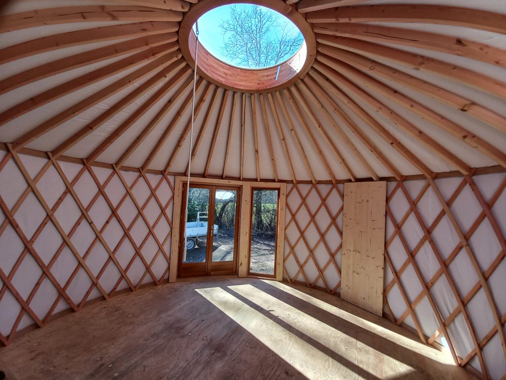 vue de l'intérieur d'une yourte de 20m² avec baie vitrée