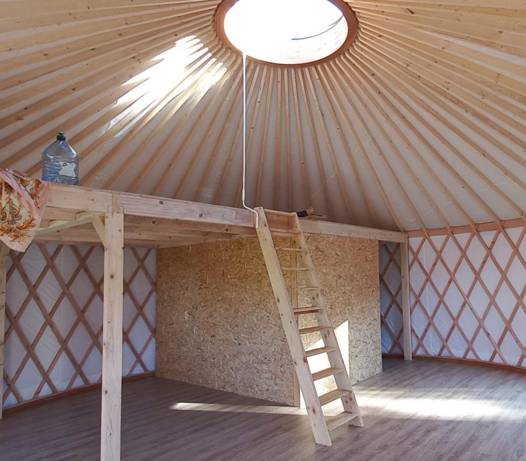 mezzanine dans une yourte contemporaine avec cloisonnement pour salle de bains et cuisine