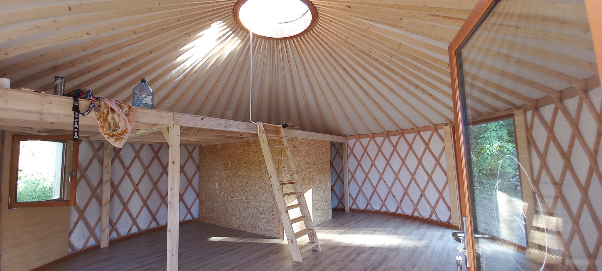 vue panoramique de l'intérieur d'une yourte contemporaine aménagée avec mezzanine