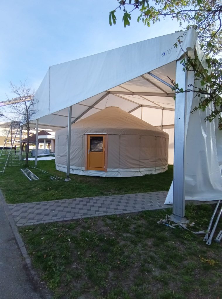 Yourte vue de l'extérieur sous un châpiteau le temps des travaux