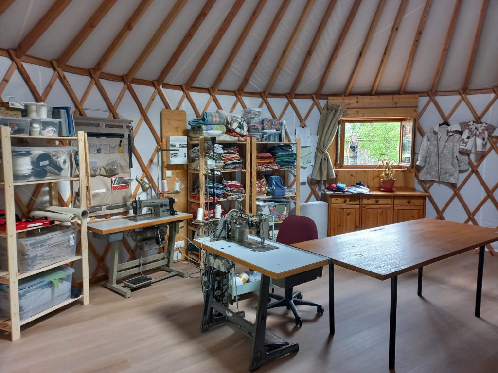 atelier artisanal dans une yourte avec machines à coudre et stock de toiles