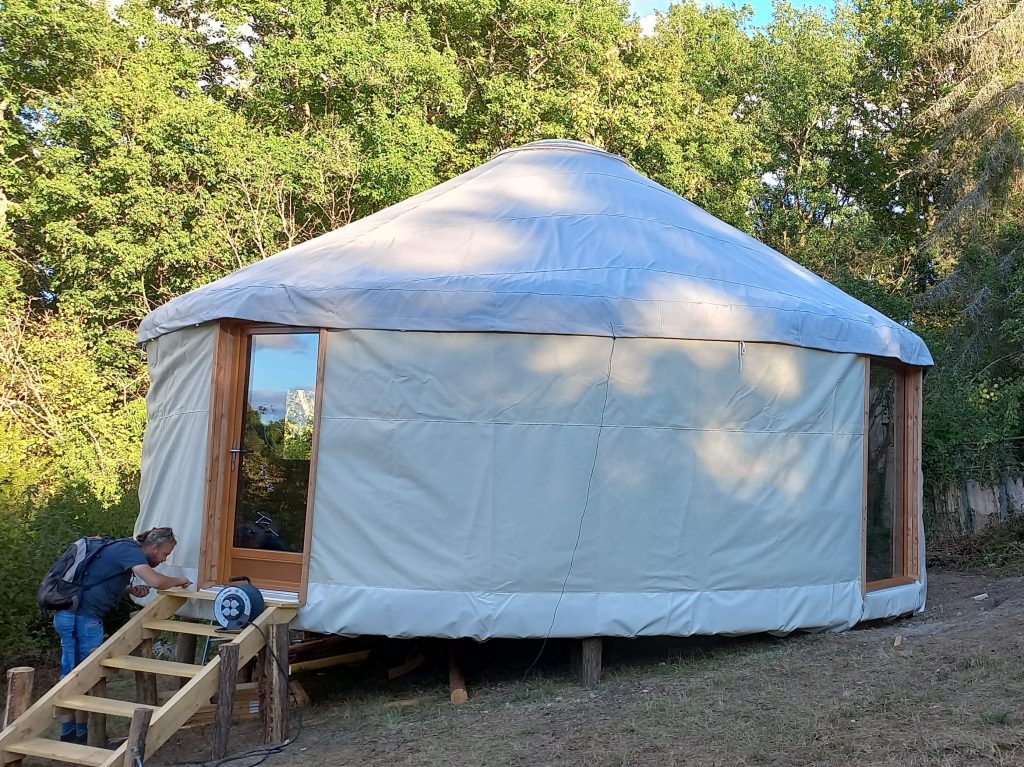 yourte contemporaine beige et blanche avec escalier d'accès