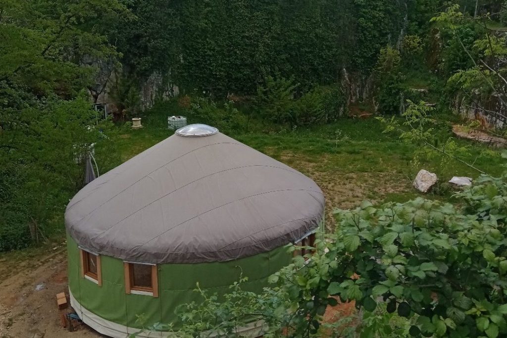 vue d'en haut d'une yourte verte et brune avec fenêtres et skydôme