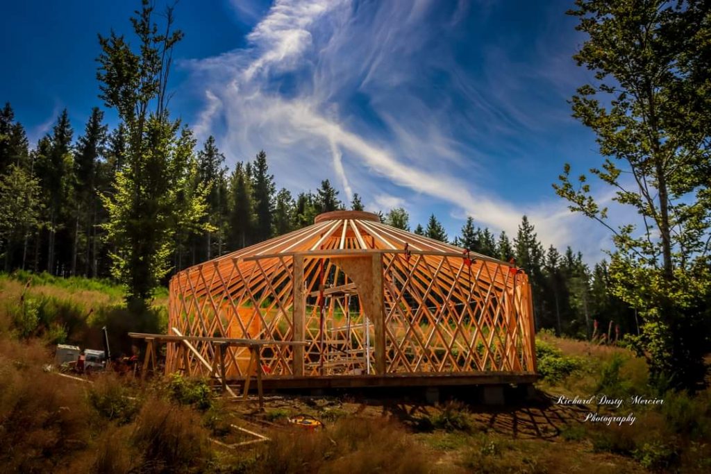 magnifique image d'une ossature en bois ronde en montagne avec beau ciel bleu et nuages