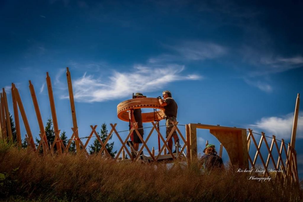 deux personnes sont en train de poser un toono, puits de lumières pour le montage d'une yourte contemporaine